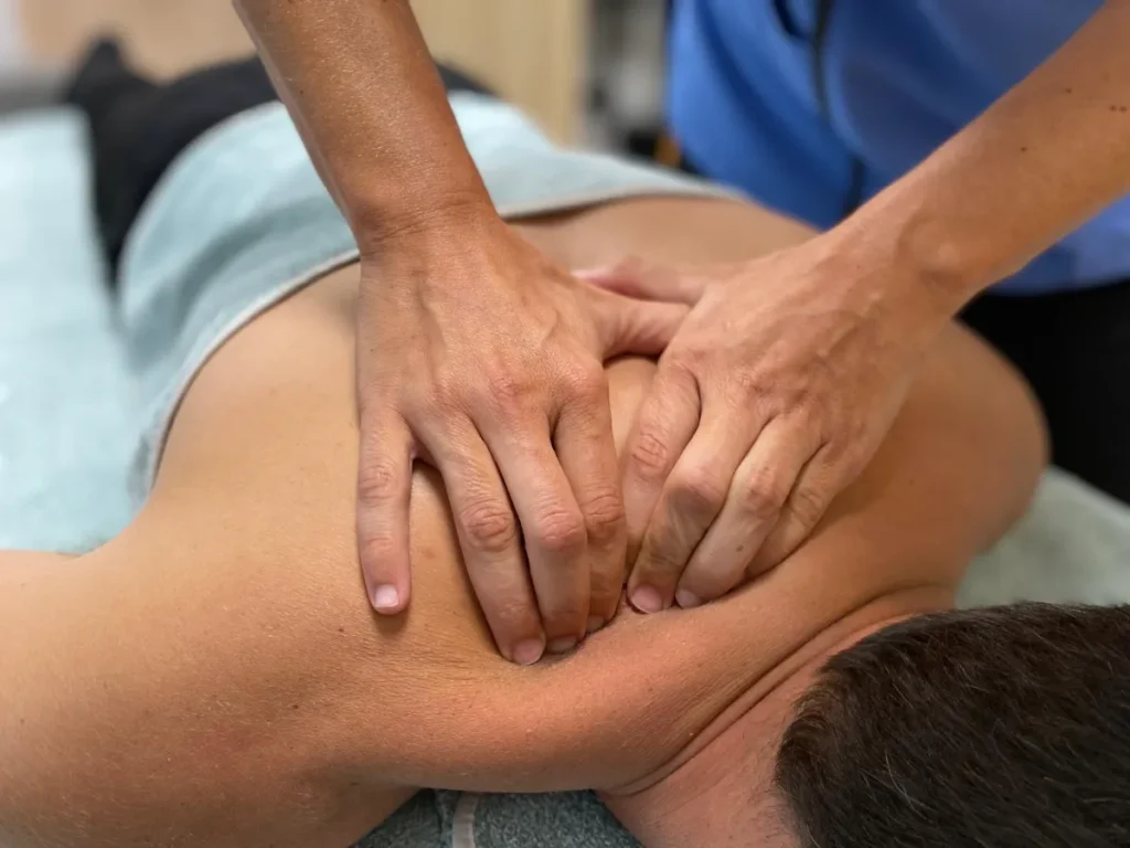 Terapia manual en el músculo trapecio de un paciente.